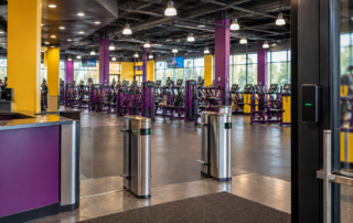 Modern fitness center with electronic access turnstiles and gym equipment