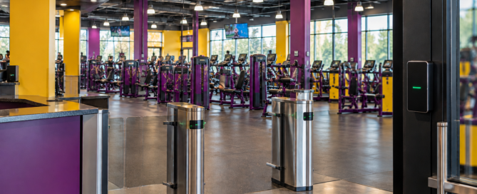 Modern fitness center with electronic access turnstiles and gym equipment